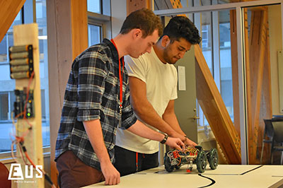 Two students working on a robotic car at a UBCEC event in the Engineering Student Centre