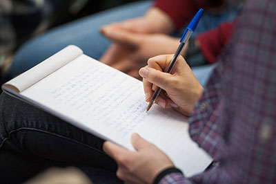 Student taking notes on a notepad