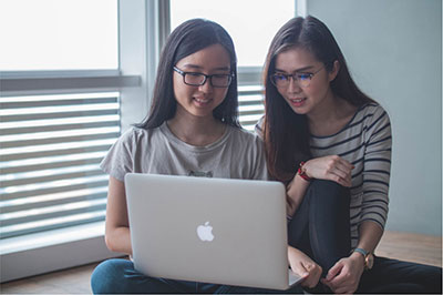 Two female students looking at a laptop