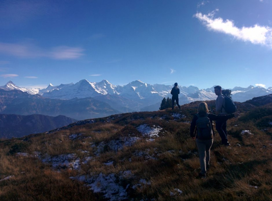 Three students standing on top of a Swiss mountain