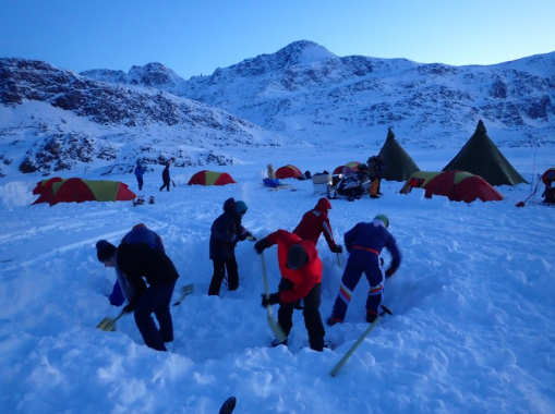 Students digging a hole in the snowy mountains.