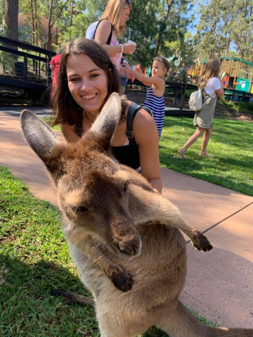 Madison smiling with a kangaroo in front of her