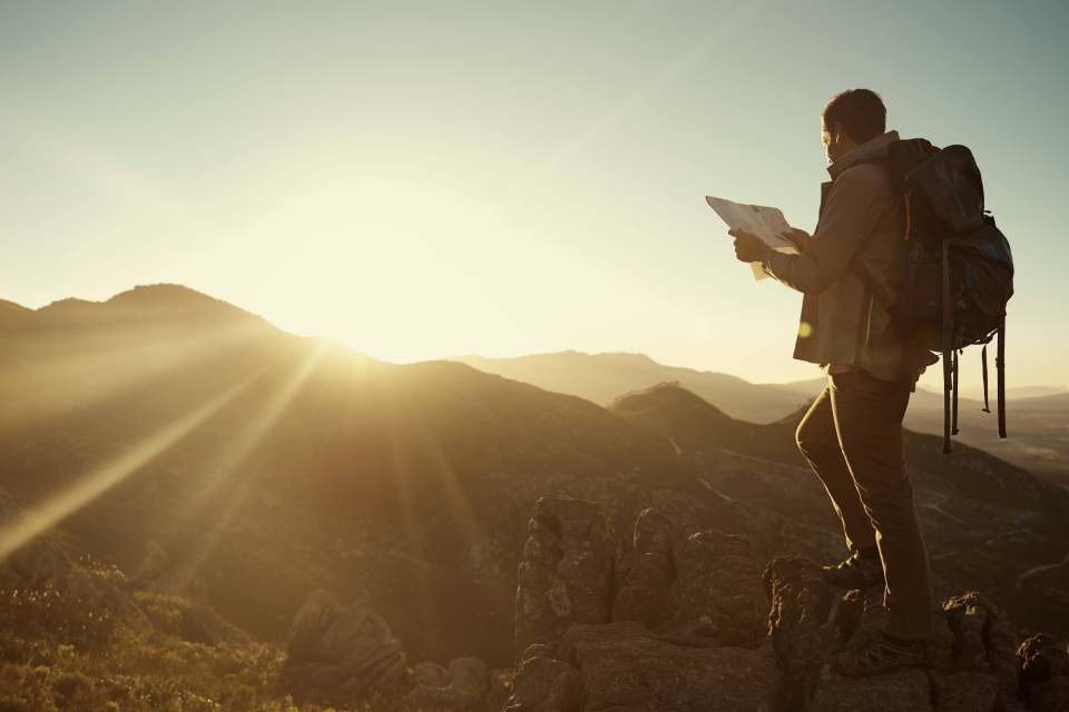 A man looking at a map on a mountain