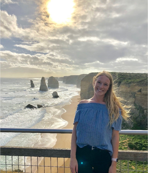 Sophie smiling with an Australian beach shoreline behind her