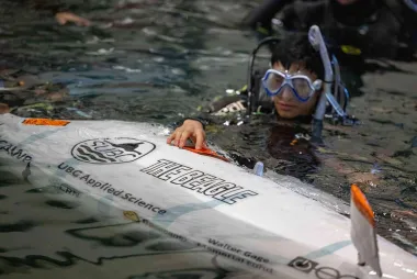 Team member in the water with submarine.