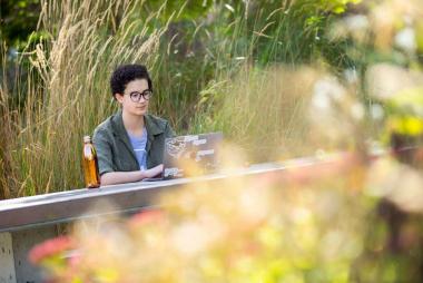 A student using her laptop outside on a sunny day