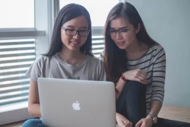 Two female students looking at a laptop