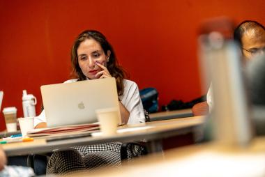 Woman at a table looking at laptop