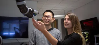 2 graduate students looking at lab