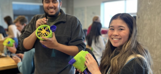 Two team members each holding a gadget.