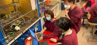 Three Mars Colony team members working on together on their laptops.