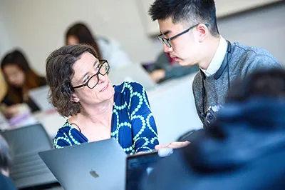 Student talking to professor in a classroom setting