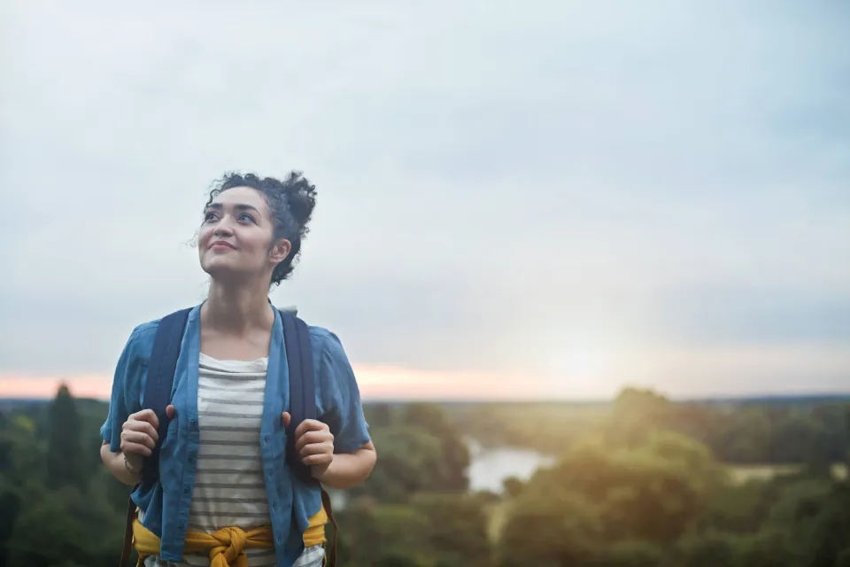 Girl smiling while grasping her backpack straps