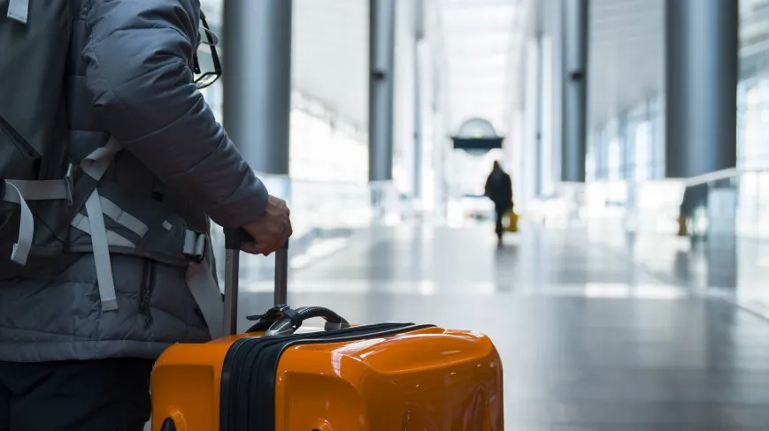 A person holding their luggage in an airport