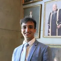 Man in suit standing in front of pictures