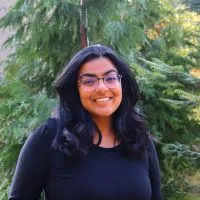 Smiling woman standing in front of a tree