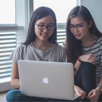 Two female students looking at a laptop